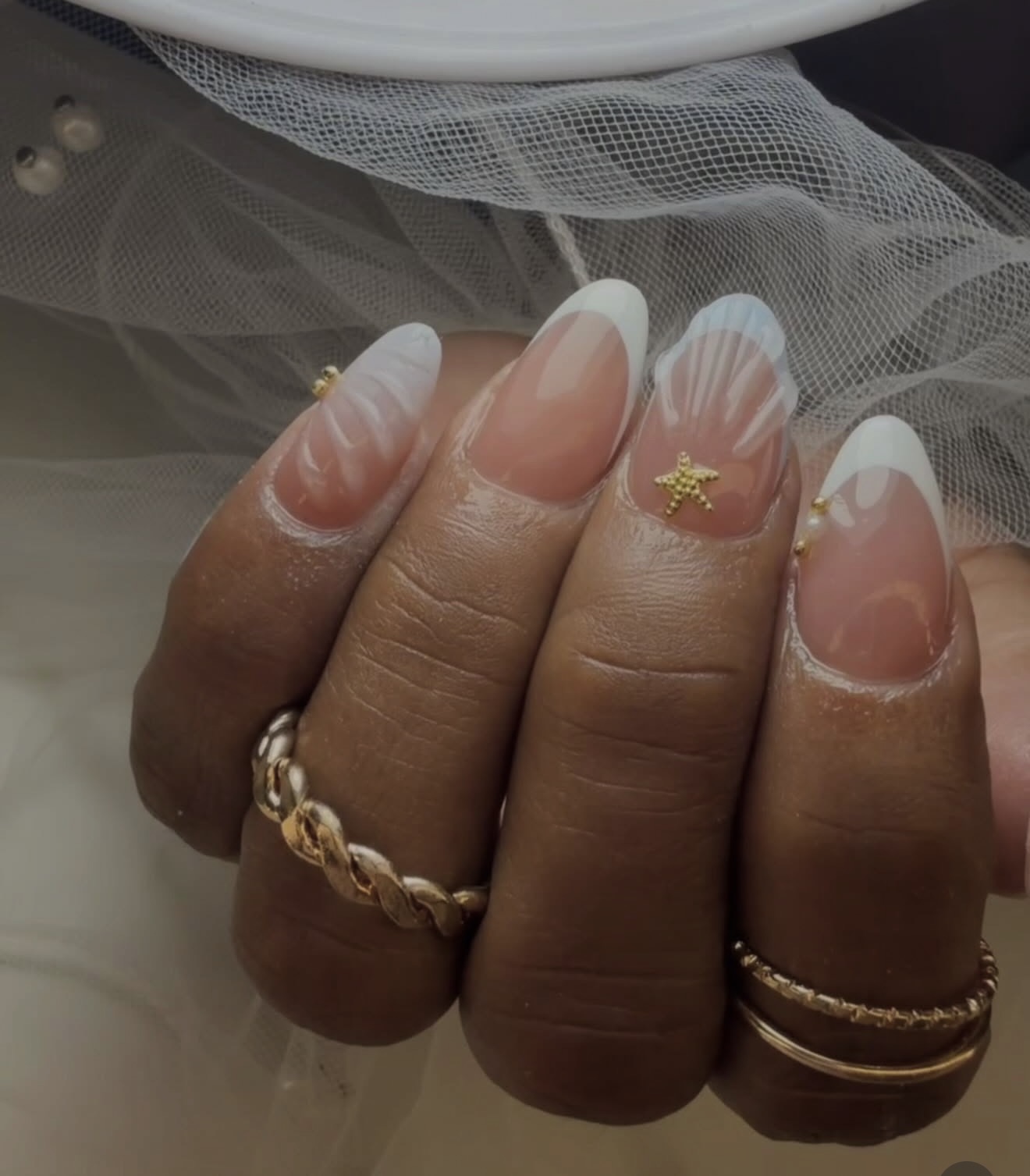 Manicura francesa con diseño de conchas