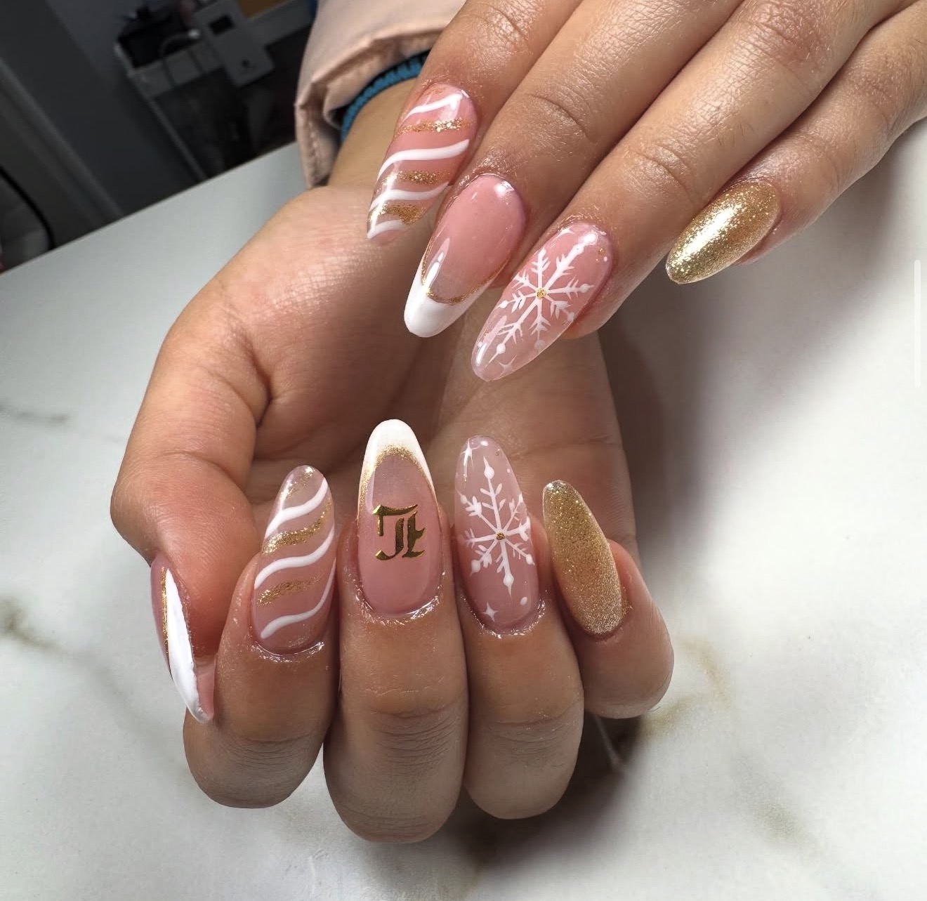 Uñas rosadas con detalles blancos y dorados